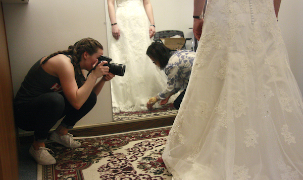 Alanna Johnson photographs May Nguyen as she works on a customer's wedding dress in her shop, May's Alterations.
