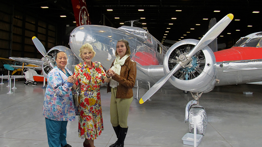 A scene from “Flight of Fantasy” written by Cherie  Frederick for the Angels Theatre Co. Left to right: MJ Dunn, Leta Powell Drake and Mattison Merritt, superimposed  in front of Ameila Earhart’s Lockheed Electra airplane.