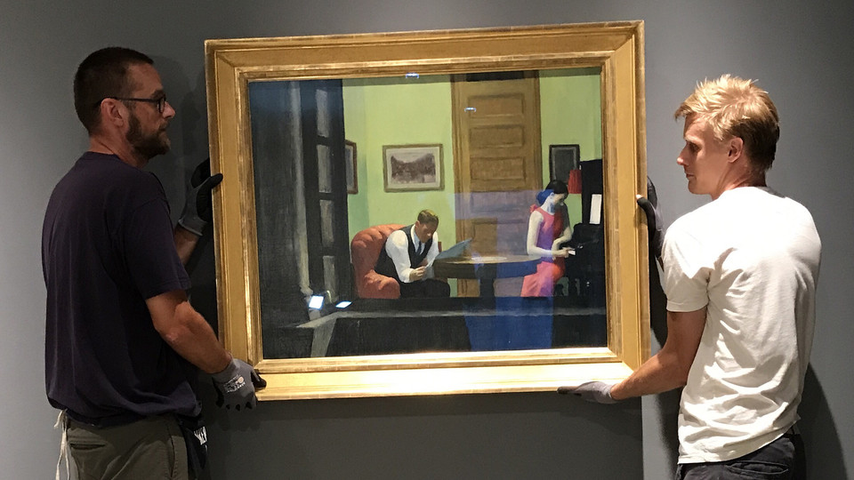 Sheldon employees install "Room in New York" by Edward Hopper. The iconic artwork is featured in the museum's new exhibition, "Sheldon Treasures."  Courtesy photo.