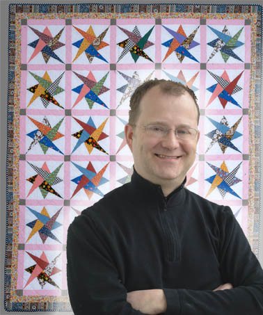 Jonathan Gregory, IQSCM Assistant Curator, and Haight quilt, in the pattern of Interlocking Triangles.