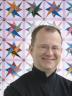 Jonathan Gregory, IQSCM Assistant Curator, and Haight quilt, in the pattern of Interlocking Triangles.