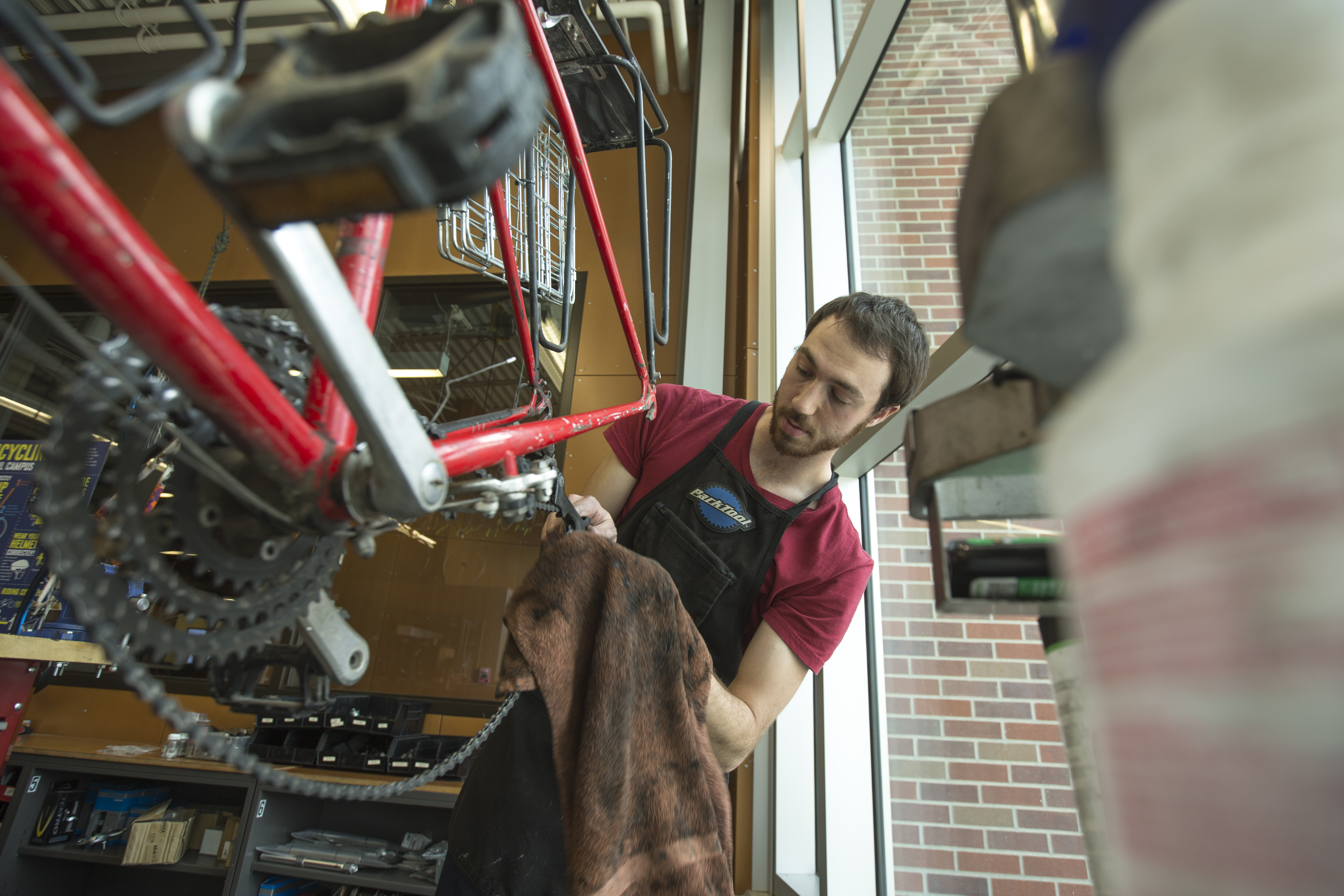Student Paul Gebers works on a bicycle as an employee in the Outdoor Adventures Bike Shop.
