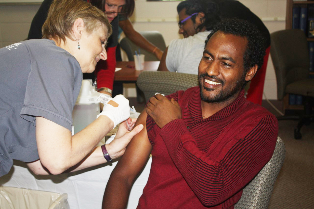 A Nebraska Medicine – University Health Center nurse gives a student an influenza vaccine during a 2016 flu shot clinic.
