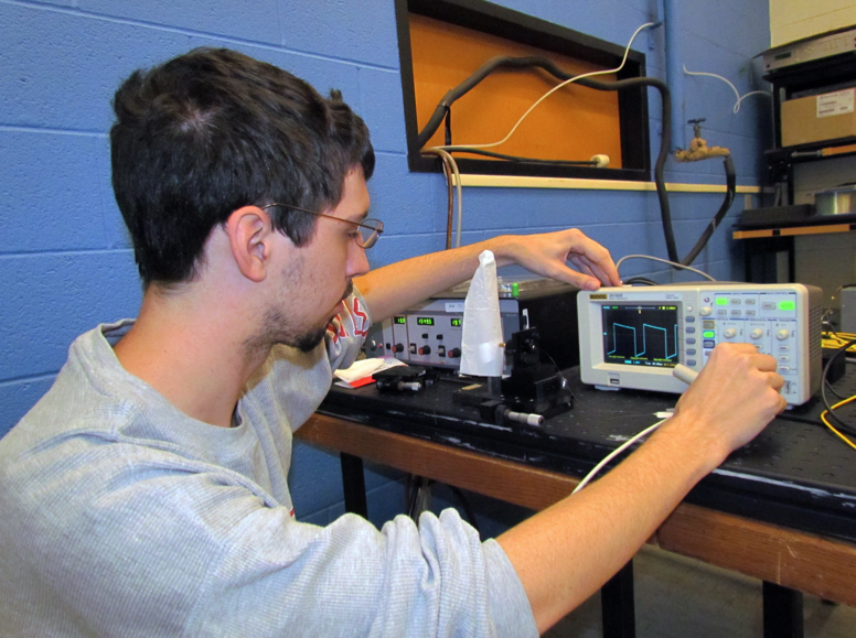 UNL electrical engineering student Thomas Fink observes the signal from an optical sensor.
