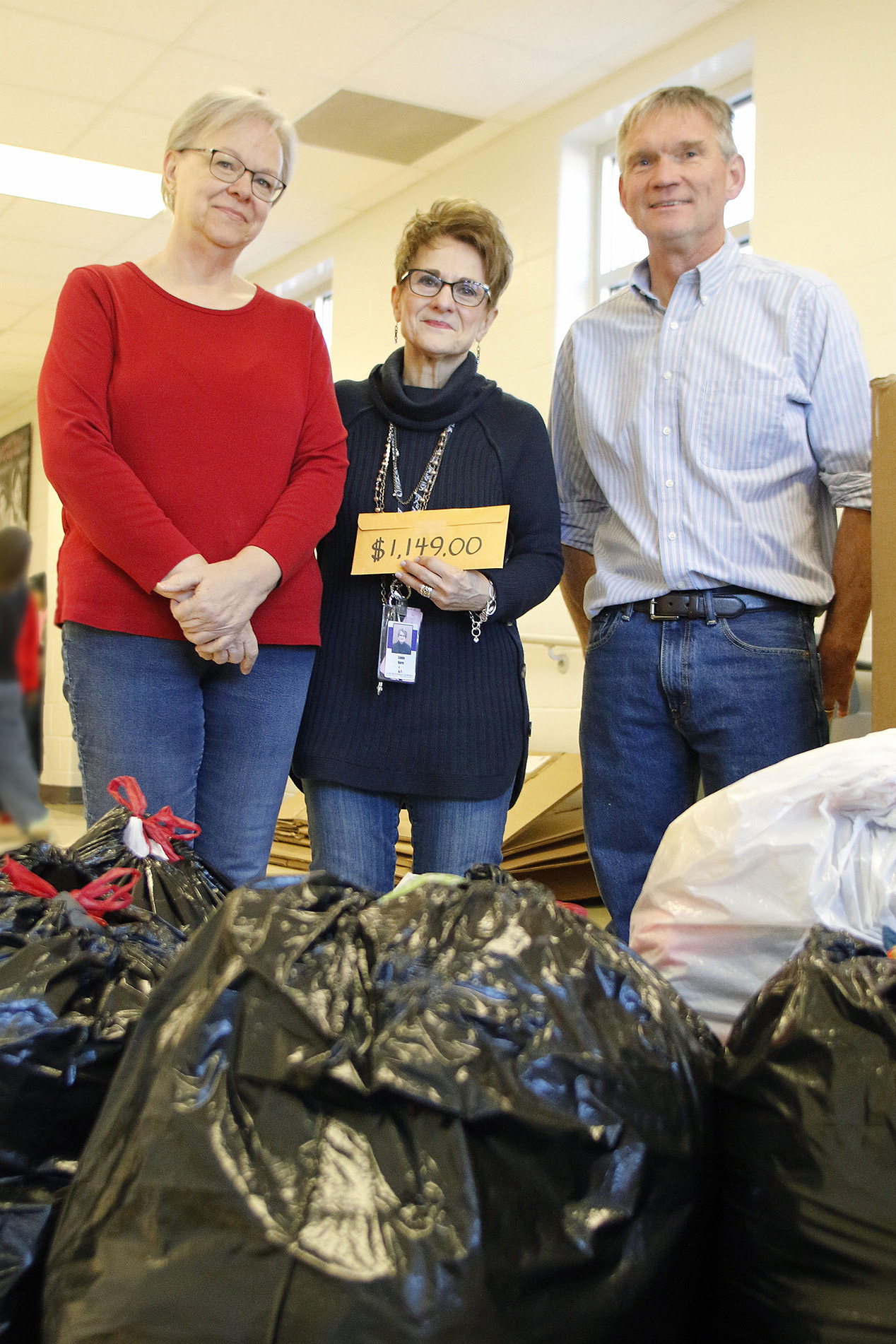 From left, Dee Ebbeka, School of Natural Resources Community Engagement member; Linda Kern, Clinton Elementary faculty care coordinator; and John Carroll, director of SNR at the University of Nebraska-Lincoln, pose with this year's Coats for Clinton donat