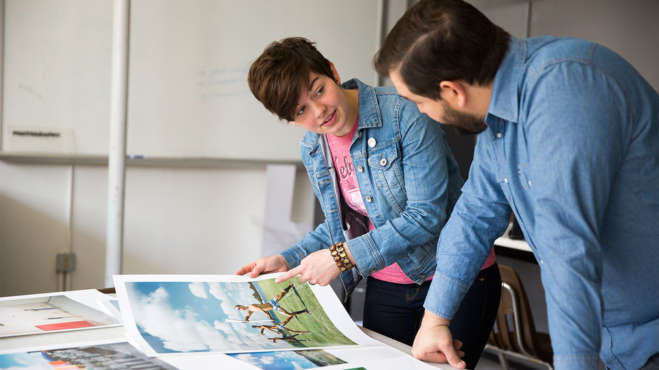 Walker Pickering (right), assistant professor of art, discusses a photography project with a UCARE student. | Courtesy Nebraska Today