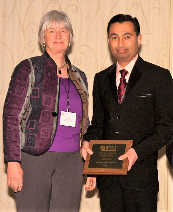 Amit Jhala (right) receives the Outstanding Reviewer Award at the 58th Annual Conference of the Weed Science Society of America. Pictured with Jhala is Sara Ward, director of publication, Weed Science Society of America.  