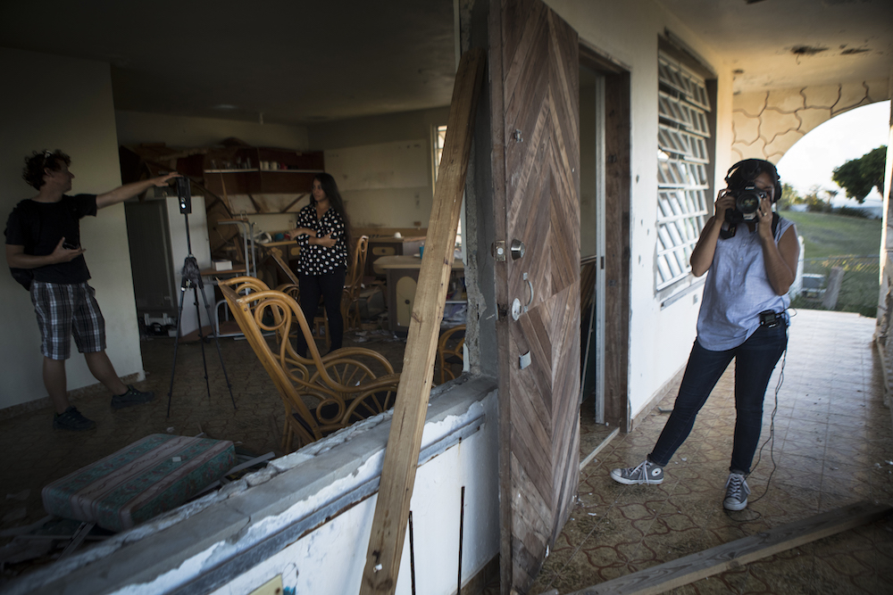 Stephanie N. Morales, in the polka dot shirt, stands in her grandmother’s house where she used to live before Hurricane Maria destroyed it. Merika Andrade worked with Ben Kreimer to reconstruct the house in virtual reality. (Photo by Merika Andrade)