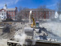 An excavator drops rubble into a truck trailer on the Cather-Pound implosion site. Data gathered during the implosion is being used to help further understand how the collapse of buildings during extreme events — like earthquakes — may affect nearby struc