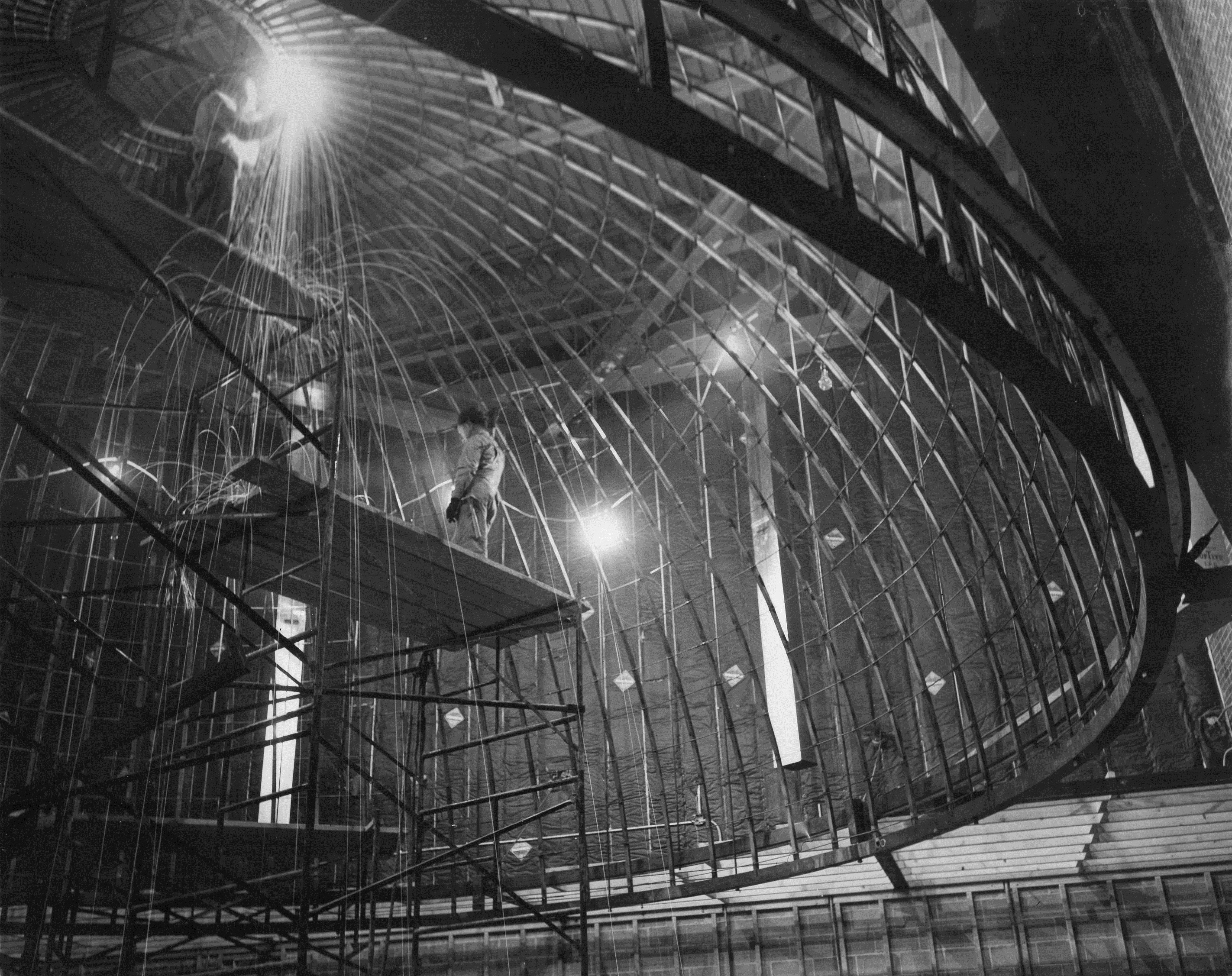 Construction workers weld metal support beams into place for the Mueller Planetarium dome in 1957. 
