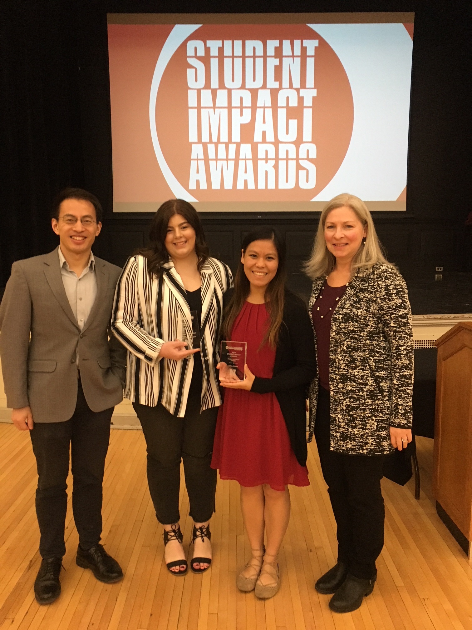 (from left) PRSSA faculty co-advisor Prof. Bryan Wang, PRSSA 2018 Vice President for Chapter Advancement Brianna Frisbie, PRSSA 2017 Chapter President Anna Fobair, and PRSSA faculty co-adviser Prof. Phyllis Larsen