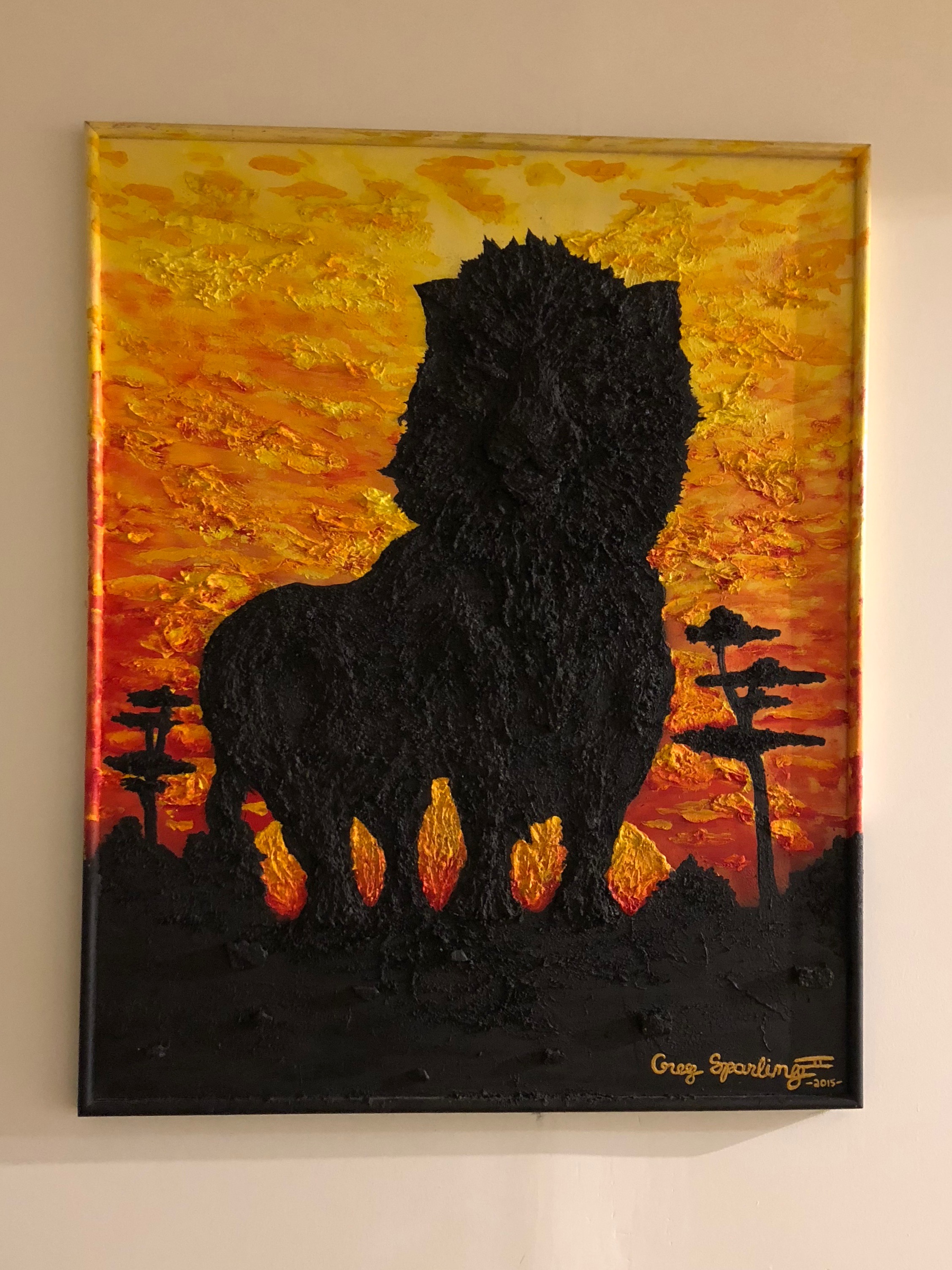 A textured painting of a lion at sunset, by Greg Sparling, hangs on a wall at the Midwestern African Museum of Art. (Photo by Katie Knight)