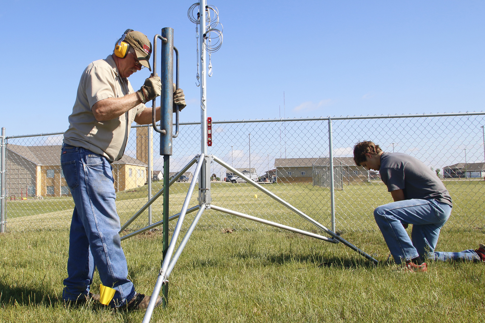 Glen Roebke, left, mesonet technician, and Regan Kerkman, NSCO student intern, install a weather station at St. Michael's Catholic Church property south of Lincoln in summer 2018. | Shawna Richter-Ryerson, Natural Resources