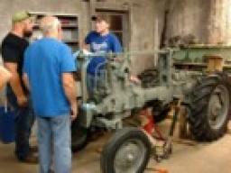 Club members discuss the next steps to restoring a prototype John Deere tractor